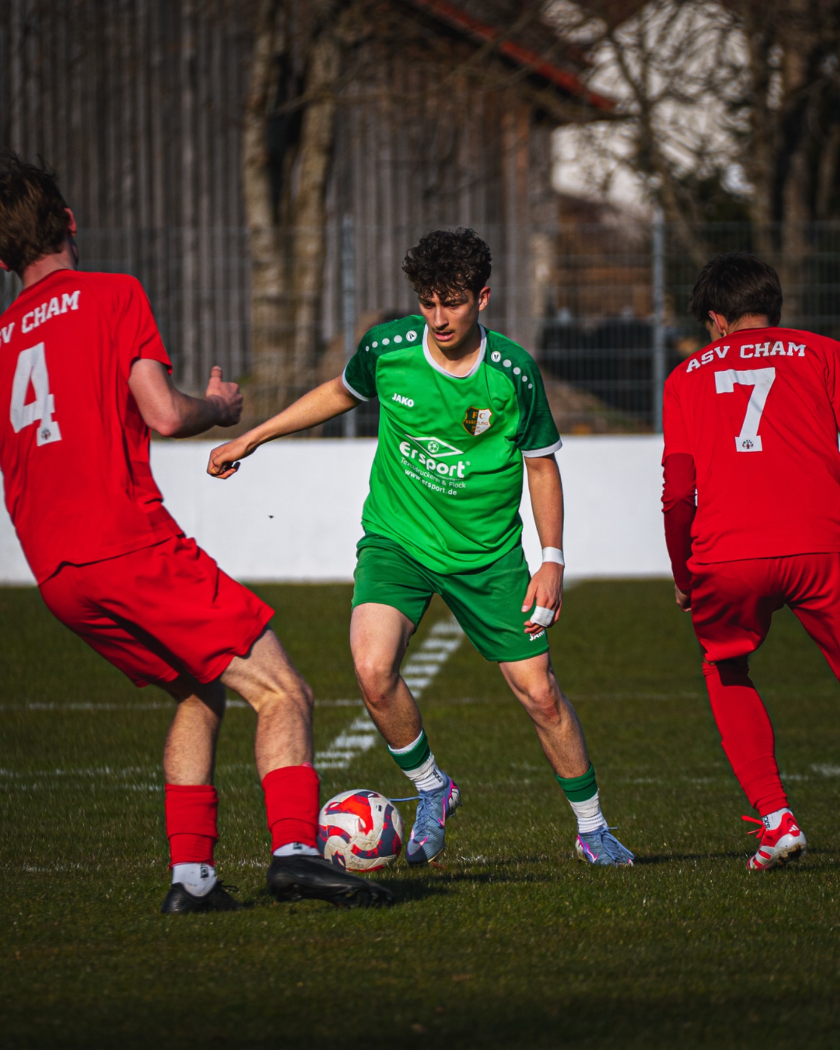 Zweikampf zwischen Spielern in Grün und Rot