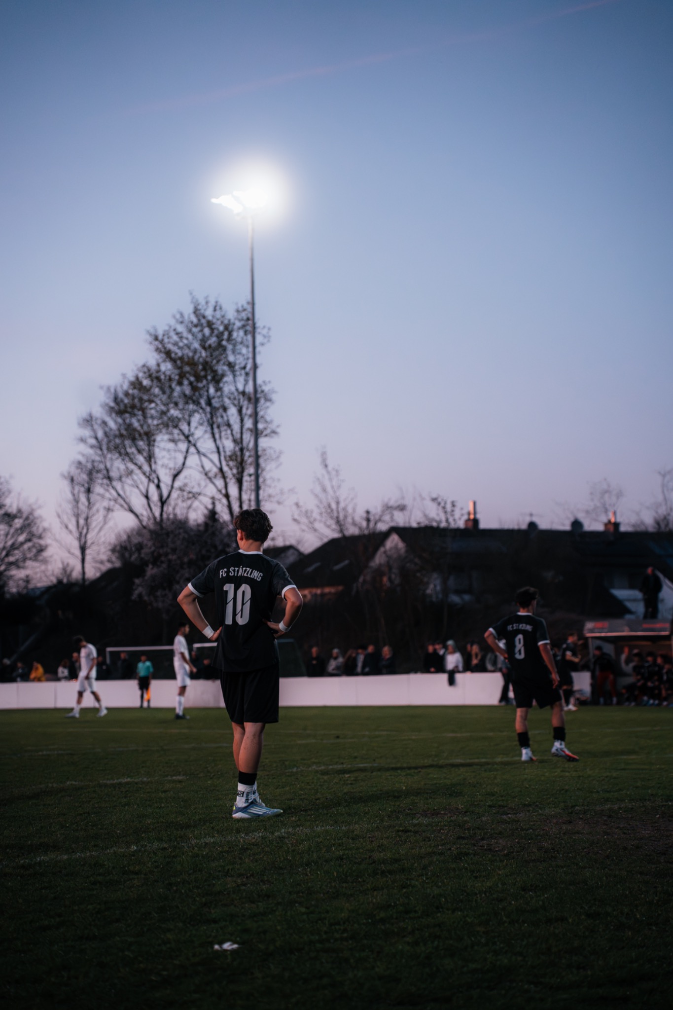 Fußballspiel unter Flutlicht in der Dämmerung